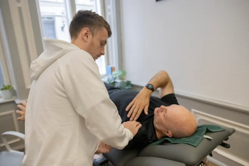 Therapeut behandelt Hüfte und unteren Rücken eines Patienten