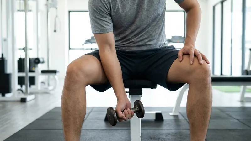 Person macht exzentrische Handgelenksübung mit einer kleinen Hantel bei Tennisarm